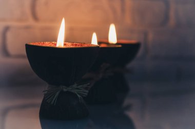 Hindistan cevizi kabuğunda yanan spa aromalı mumlar cam beyaz masa üzerinde, rahat ev içi.
