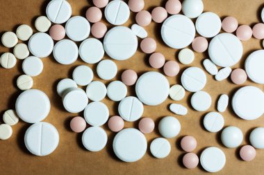 Beyaz haplar, tabletler, sarı turuncu arka planda kapsüller. Fotokopi alanı ile tedavi tedavisi için ilaç reçetesi