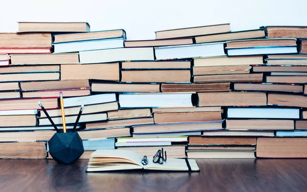 Notebook, pencils, glasses and stack of books, school background for education learning concept