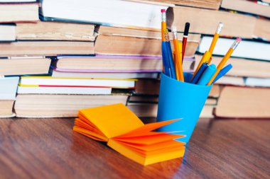 Kalem tutacağı, not kağıdı ve kitap yığını, eğitim öğrenim konsepti için okul geçmişi