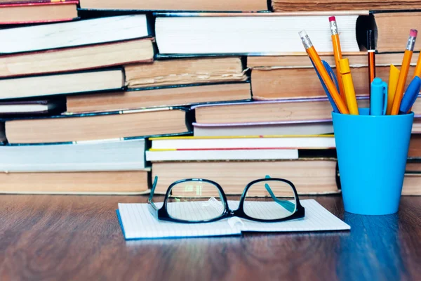 Kalem tutacağı, gözlük, defter ve kitap yığını, eğitim öğrenme konsepti için okul geçmişi