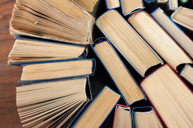 Kitapçıda ya da kütüphanede eski ve iyi kullanılmış kitaplar ya da ders kitapları. Bir sürü kitap yığını. Ahşap masa manzaralı sert ciltli kitaplar. Kopya alanı ile okula geri dön