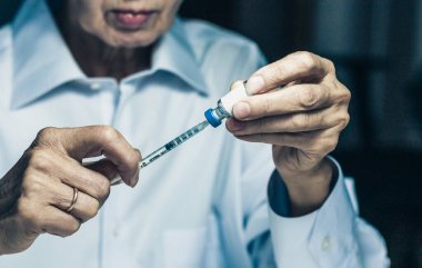 Diyabet için bir şişe insülin ve yaşlı kadınların ellerine enjeksiyon enjeksiyonu, sağlık konsepti geçmişi