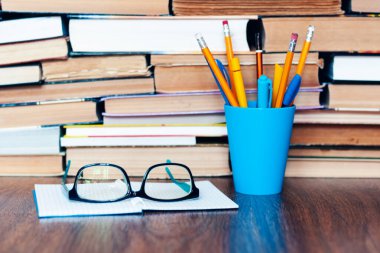 Kalem tutacağı, gözlük, defter ve kitap yığını, eğitim öğrenme konsepti için okul geçmişi