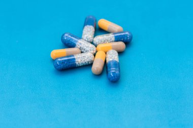 Beyaz haplar, haplar, mavi arka planda kapsüller. Fotokopi alanı ile tedavi tedavisi için ilaç reçetesi