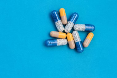 Beyaz haplar, haplar, mavi arka planda kapsüller. Fotokopi alanı ile tedavi tedavisi için ilaç reçetesi