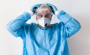 Coronavirus Covid-19 konsepti. Gözlüklü yaşlı bir doktor ve hastanede sıkı çalıştıktan sonra korunmak için maske takıyor. Wuhan, Çin salgını virüsü. Cov-19 belirtileri karantina altında. 