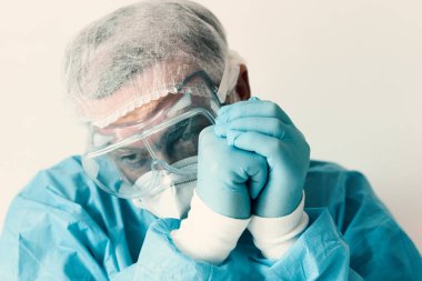 Coronavirus Covid-19 konsepti. Gözlüklü yaşlı bir doktor ve hastanede sıkı çalıştıktan sonra korunmak için maske takıyor. Wuhan, Çin salgını virüsü. Cov-19 belirtileri karantina altında. 