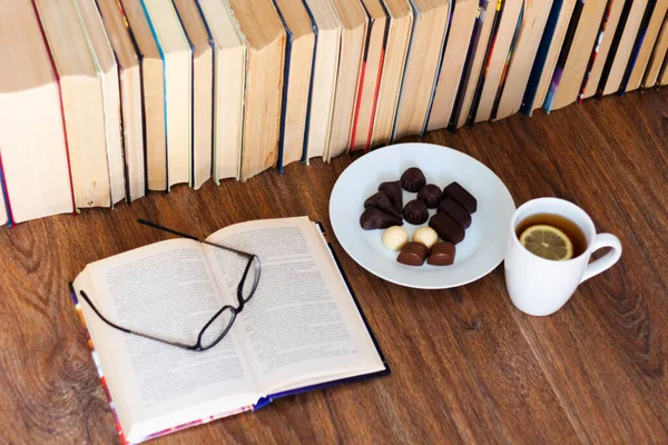 Open Textbook Glasses Cup Tea Chocolate Candies White Plate Stack — Stock Photo, Image