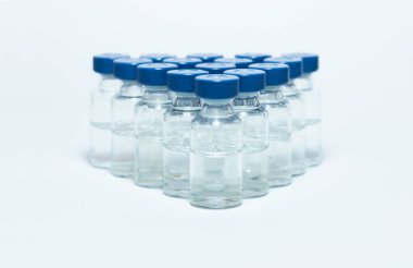 Aşı için mavi alüminyum kapaklı aşı enjeksiyon sıvısı içeren cam ilaç şişeleri, Coronavirus Covid-19 konsepti.
