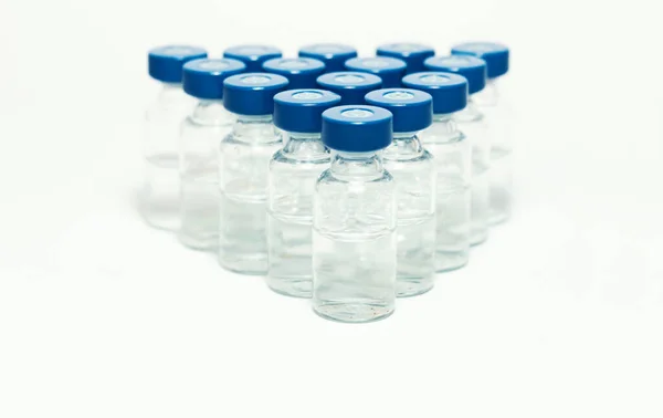 Glass medicine bottles with vaccine injection fluid with blue aluminium caps for vaccination, Coronavirus Covid-19 concept