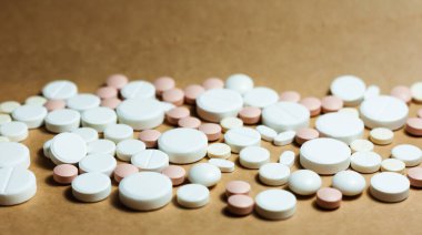 Beyaz haplar, tabletler, sarı turuncu arka planda kapsüller. Fotokopi alanı ile tedavi tedavisi için ilaç reçetesi