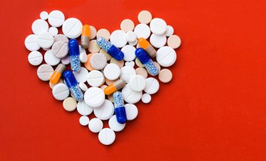 Bir sürü hap, tablet, kırmızı turuncu arka planda kapsüller. Fotokopi alanı ile tedavi tedavisi için ilaç reçetesi