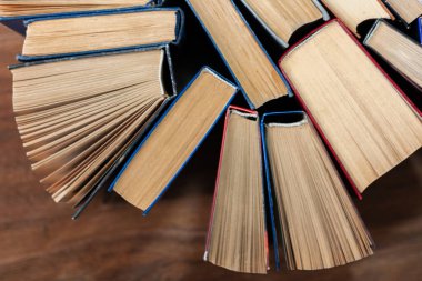 Kitapçıda ya da kütüphanede eski ve iyi kullanılmış kitaplar ya da ders kitapları. Bir sürü kitap yığını. Ahşap masa manzaralı sert ciltli kitaplar. Kopya alanı ile okula geri dön