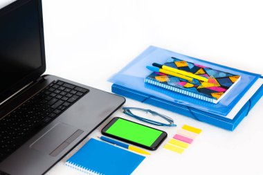 Evden iş, yeşil ekran cep telefonu, dizüstü bilgisayar, kitaplar ve defter. Eğitim geçmişi, salgın sırasında evde çalışma ortamı. Evde kalma konsepti Coronavirus COVID-19 'u durdurur.