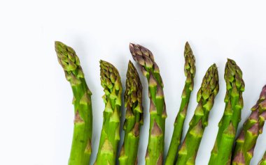 Beyaz arka planda taze çiğ kuşkonmaz, vejetaryen konsepti. Yeşil çimen serçesi çubukları, sebzeler için yiyecek.