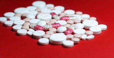 Bir sürü hap, tablet, kırmızı turuncu arka planda kapsüller. İlaç tedavisi için ilaç reçetesi. Fotokopi uzayı ile sağlık hizmeti konsepti. Coronavirus 2019, Corona virüsü karantinası, Covid-19