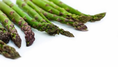 Beyaz arka planda taze çiğ kuşkonmaz, vejetaryen konsepti. Yeşil çimen serçesi çubukları, sebzeler için yiyecek.