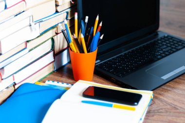 Ders kitabı, defter, dizüstü bilgisayar, cep telefonu akıllı telefon, yığınla kitap. Evde eğitim geçmişi, evde kalma kavramı