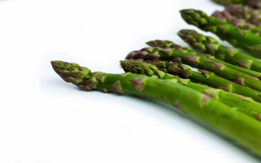 Beyaz arka planda taze çiğ kuşkonmaz, vejetaryen konsepti. Yeşil çimen serçesi çubukları, sebzeler için yiyecek.