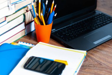 Ders kitabı, defter, dizüstü bilgisayar, cep telefonu akıllı telefon, yığınla kitap. Evde eğitim geçmişi, evde kalma kavramı