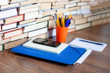 Ders kitabı, defter, cep telefonu akıllı telefon, yığınla kitap. Evde eğitim geçmişi, evde kalma kavramı