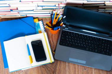Ders kitabı, defter, dizüstü bilgisayar, cep telefonu akıllı telefon, yığınla kitap. Evde eğitim geçmişi, evde kalma kavramı