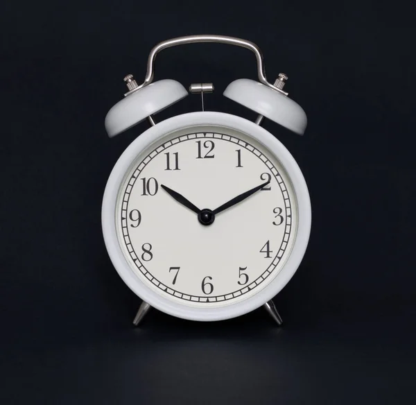 Old-style alarm clock, black and white, it\'s ten past ten.