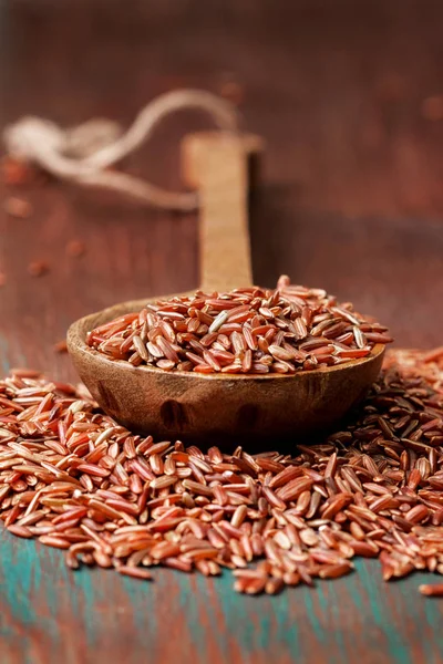 Κόκκινο ρύζι με ένα ξύλινο κουτάλι — Φωτογραφία Αρχείου