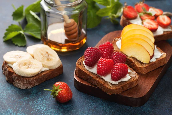 Toasts with cream cheese and fresh berries — Stock Photo, Image