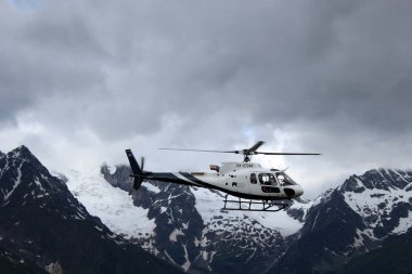 Helikopter karlı dağların arkasında