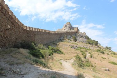 Kuleleri ve duvarları olan eski bir kale.