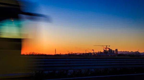 Le soleil se couche derrière une industrie — Photo