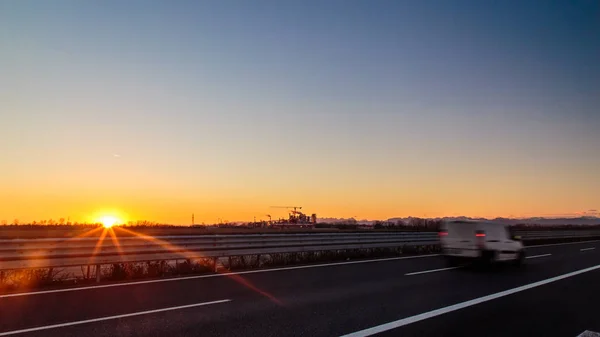 Le soleil se couche derrière une industrie — Photo