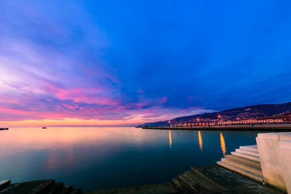 Colorido atardecer frente a la ciudad de Trieste — Foto de Stock