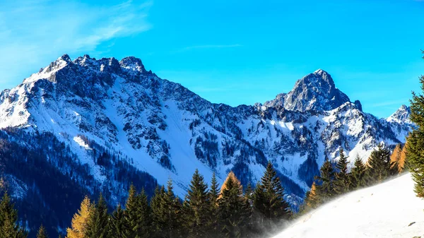 Sonniger Wintertag mit schneebedeckten Bergen — Stockfoto