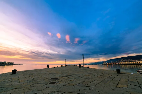 Färgsprakande solnedgång framför staden Trieste — Stockfoto