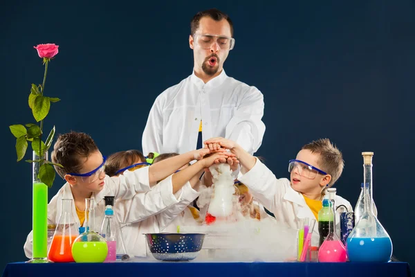Miúdos felizes com cientista a fazer experiências científicas no laboratório — Fotografia de Stock