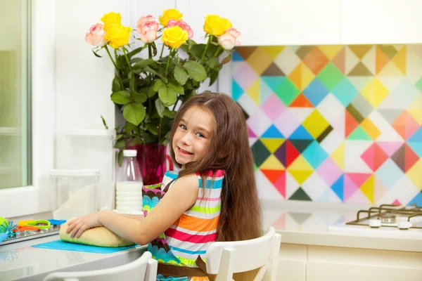 Menina preparando a massa para um biscoito na cozinha — Fotografia de Stock