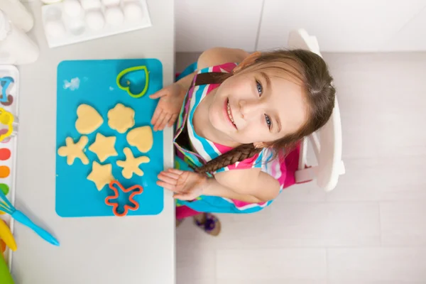 Malá holčička, připravuje se souborem cookie v kuchyni. — Stock fotografie