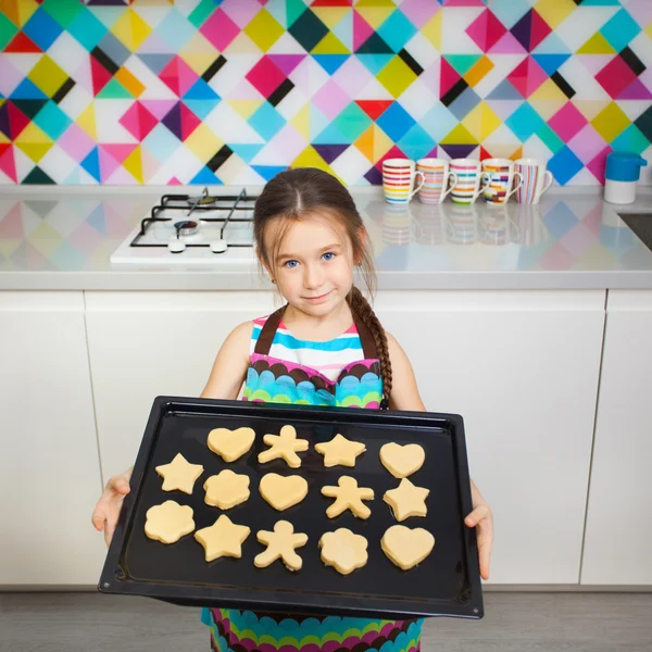 Malá holčička, připravuje se souborem cookie v kuchyni. — Stock fotografie