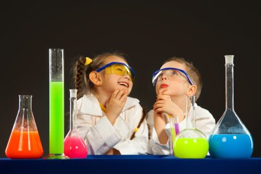 Küçük erkek ve kız laboratuvar deneylerinde yapıyor