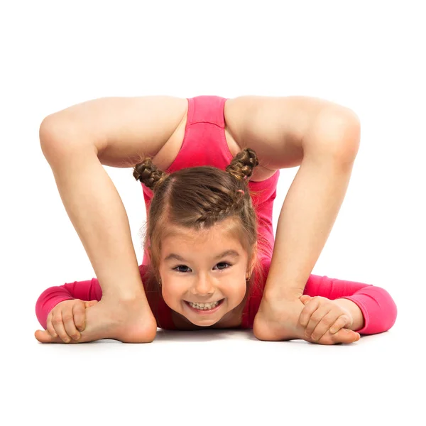 Flexible niña gimnasta haciendo acrobacia sobre fondo blanco —  Fotos de Stock