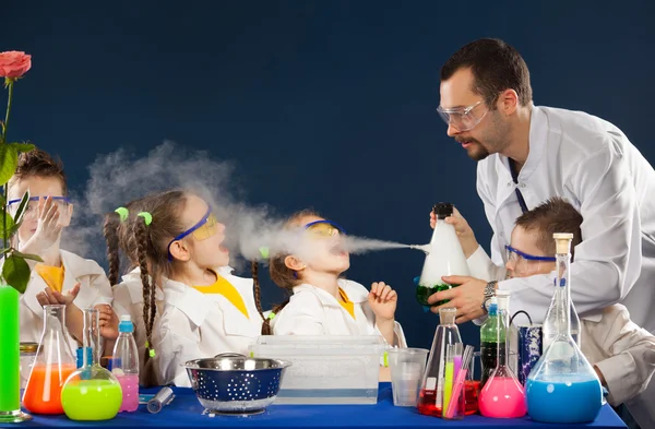 Glückliche Kinder mit Wissenschaftlern, die naturwissenschaftliche Experimente im Labor durchführen — Stockfoto