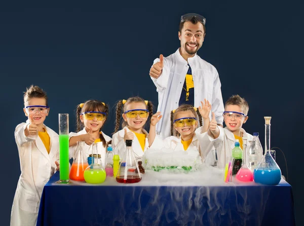 研究室での科学実験を行う科学者と幸せな子供 — ストック写真