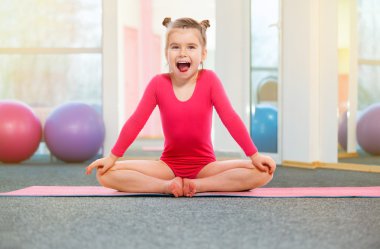 Sevimli küçük kız jimnastikçi içinde jimnastik salonu. Eğitim, spor, fitness kavramı