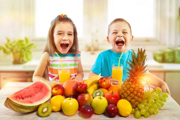 Crianças com frutas e suco fresco na cozinha, alimentação saudável — Fotografia de Stock