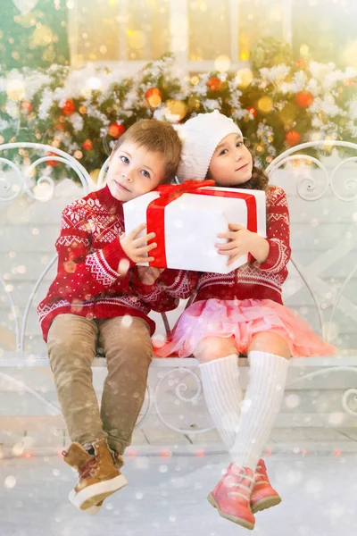 Glada barn flicka och pojke håller julklapp — Stockfoto