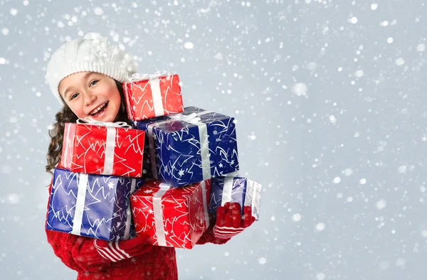 Felice bambina con regali di Natale su sfondo neve — Foto Stock