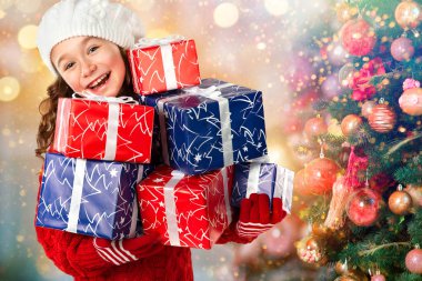 Happy little girl with many gifts near Christmas tree clipart